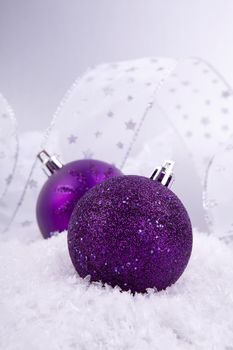 beautiful christmas decoration in purple and silver on white snow sparkle