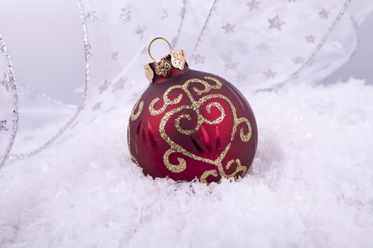 beautiful gold and red christmas decoration on white snow sparkle