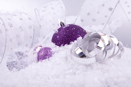 beautiful christmas decoration in purple and silver on white snow sparkle