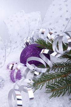 beautiful christmas decoration in purple and silver on white snow sparkle