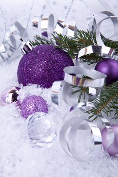 beautiful christmas decoration in purple and silver on white snow sparkle