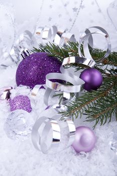 beautiful christmas decoration in purple and silver on white snow sparkle