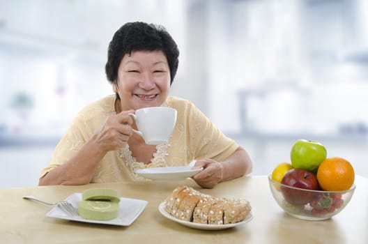 Asian senior woman having breakfast at home