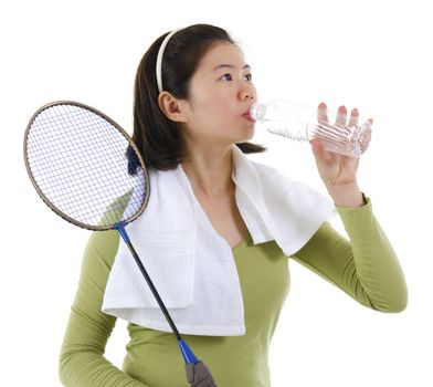 Asian woman drinking water after playing badminton over white background