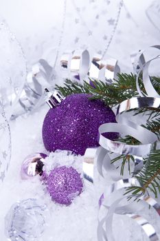 beautiful christmas decoration in purple and silver on white snow sparkle