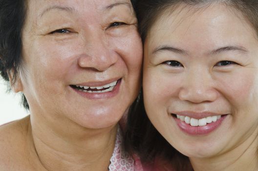 Asian senior mother and adult daughter face close up