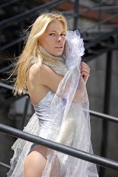 beautiful blonde fiancee with veil on stairs