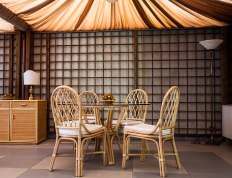 Glass table with wickler chairs in an elegant interior