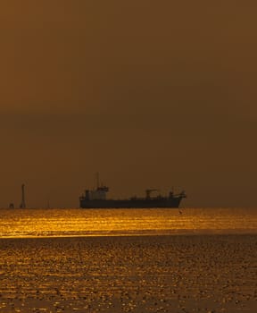 Golden sea with ocean liner at sunset