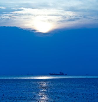 Blue sea with ocean liner at sunset