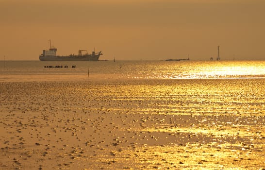 Golden sea with ocean liner at sunset