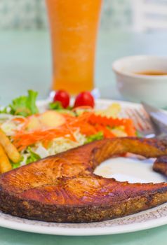 Smoke Salmon steak with vegetable salad on white plate