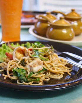 Tasty spice spaghetti with green curry, basil leaf and seafood