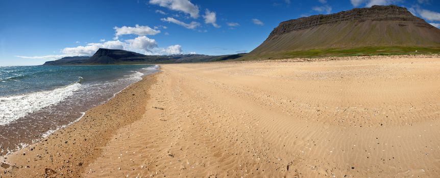 Beach under the mighty fjords rising from the sea in the Westfjords Peninsula, northwestern Iceland