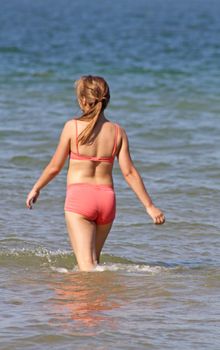 stunning teenage girl in the sea wearing a bikini