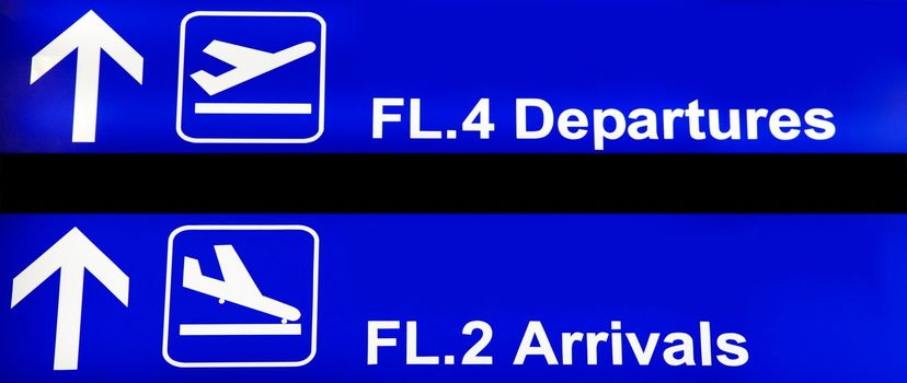 Blue airport sign with arrivals and departures