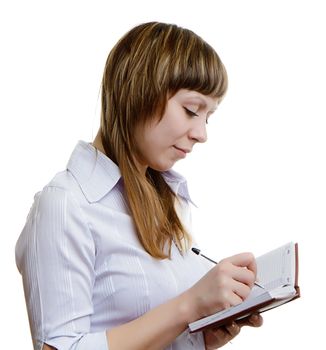 young girl in a white blouse writes in a notebook