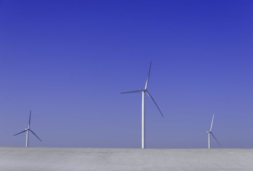 three wind turbines in fields covered with snow