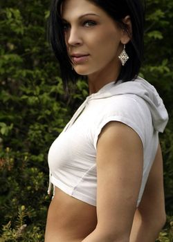 Beautiful female model with belly button piercing in the woods