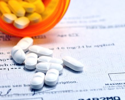 Closeup macro shot of prescription drugs on script written for drugs.