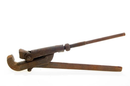 Big used rusty wrench on white background.