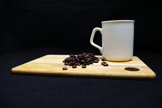 Coffee beans and a cup on a wooden tray