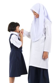 Young Southeast Asian Muslim girl  greeting to her elder sister over white background