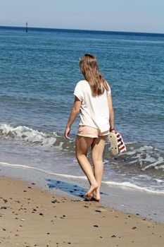 teenage girl walking on a beach