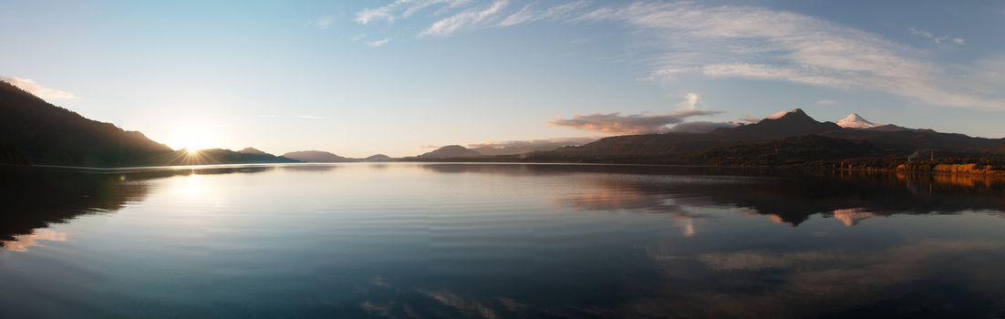 Sunset Panorama on the Coñaripe city lake and reflection of the Villarica Volcano (Chile)
