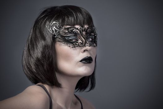 Beautiful woman with black mysterious venetian mask