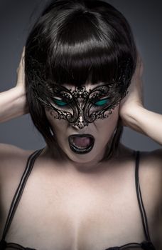 Woman screaming, closeup portrait of sexy young over grey background