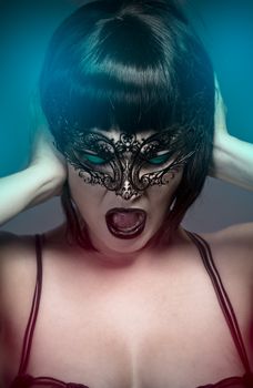 Woman screaming, closeup portrait of sexy woman with venetian mask
