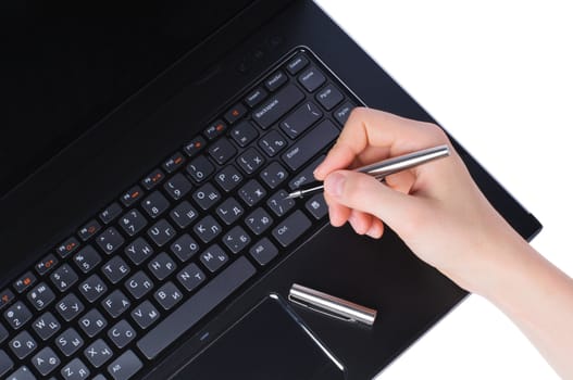 Hand with fountain pen on laptop keyboard isolated on white background