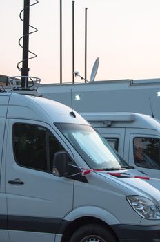 White broadcast trucks recording and broadcasting a live event