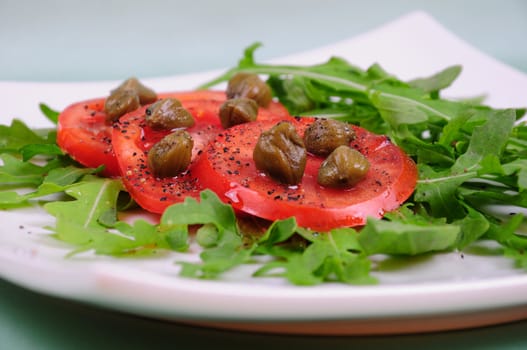 Salad with fresh tomatoes, capers and arugula