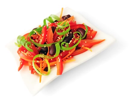 A salad of tomatoes, sweet peppers, red beans, carrots with sesame