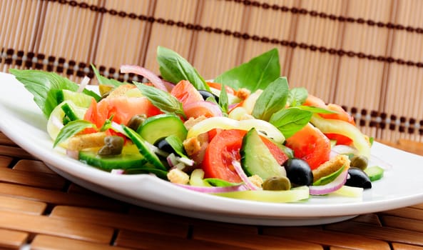 Fresh vegetable salad with basil, capers, olives, marinated with croutons