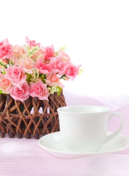 pink roses in wood basket on fabric pink background