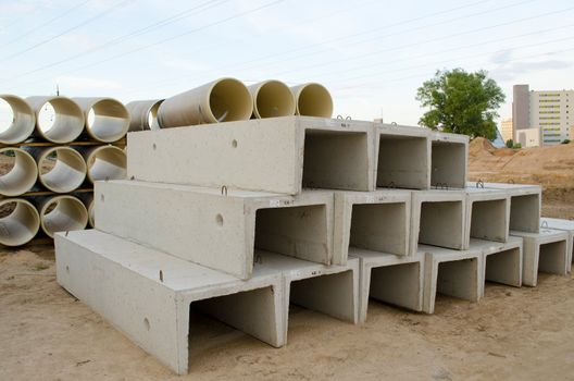 Materials used in road construction works. Concrete molds and plastic sewage pipes.