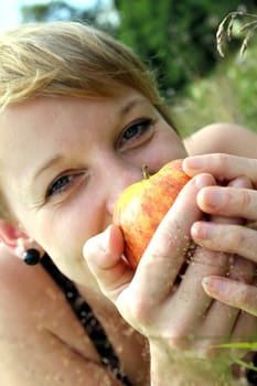 girl with apple on summer meadow
