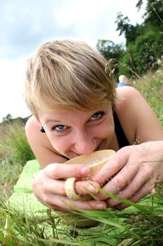 girls is drinking from a cup on a meadow