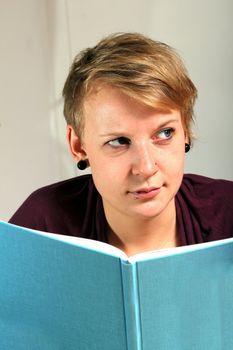critically looking girl is reading a book