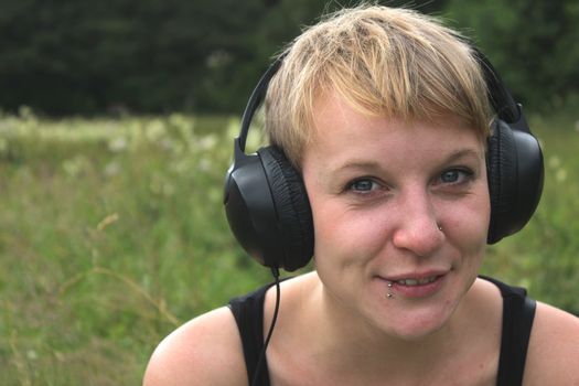 girl on meadow with headphones