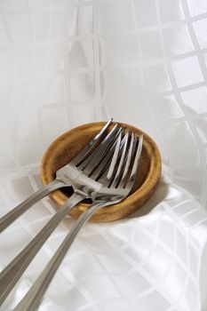 Shiny stainless steel forks on white fabric