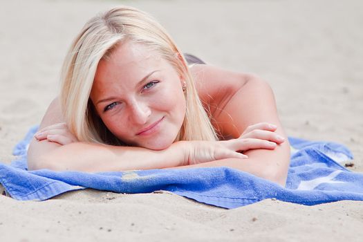 Photo of a young and beautiful woman resting on the sea coast