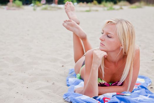 Photo of a young and beautiful woman resting on the sea coast