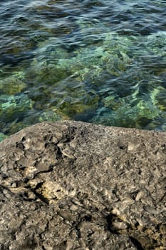 Background of a rough textured rock alongside cool pure fresh water in a rock pool