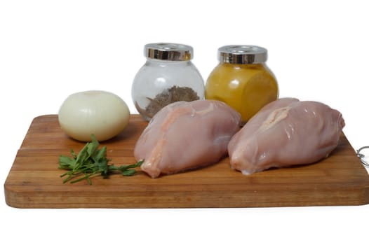 A pair of skinless chicken breasts on a cutting board