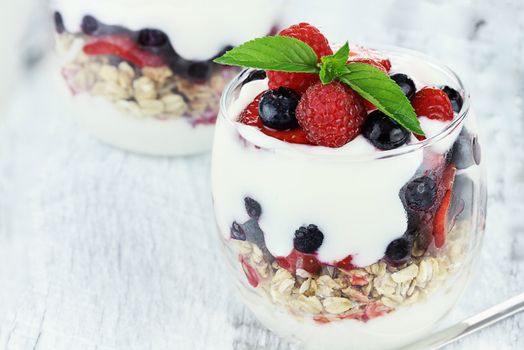Delicious and healthy yogurt parfait made with Greek yogurt, fresh berries and mint. Extreme shallow depth of field.
