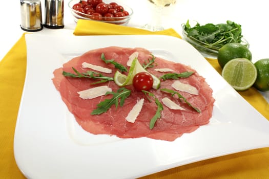 Beef carpaccio with parmesan, rocket, tomatoes and white wine